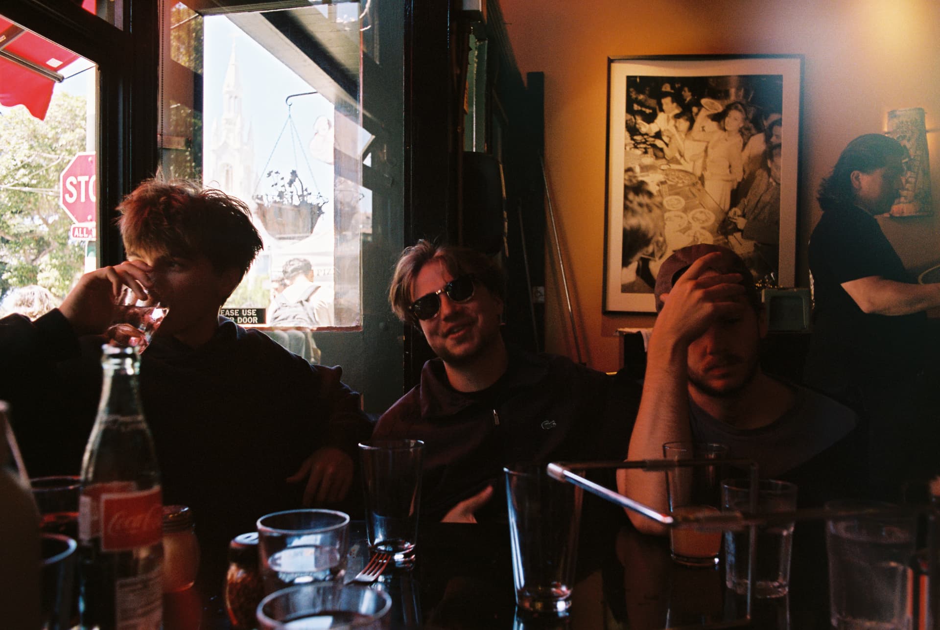Friends gathered around a cafe table in afternoon light